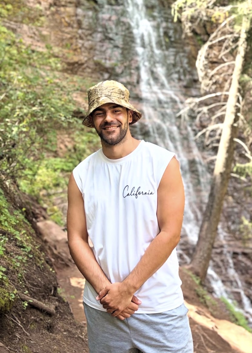 Ilya, fondateur de Beyond Borders Tours, devant une cascade